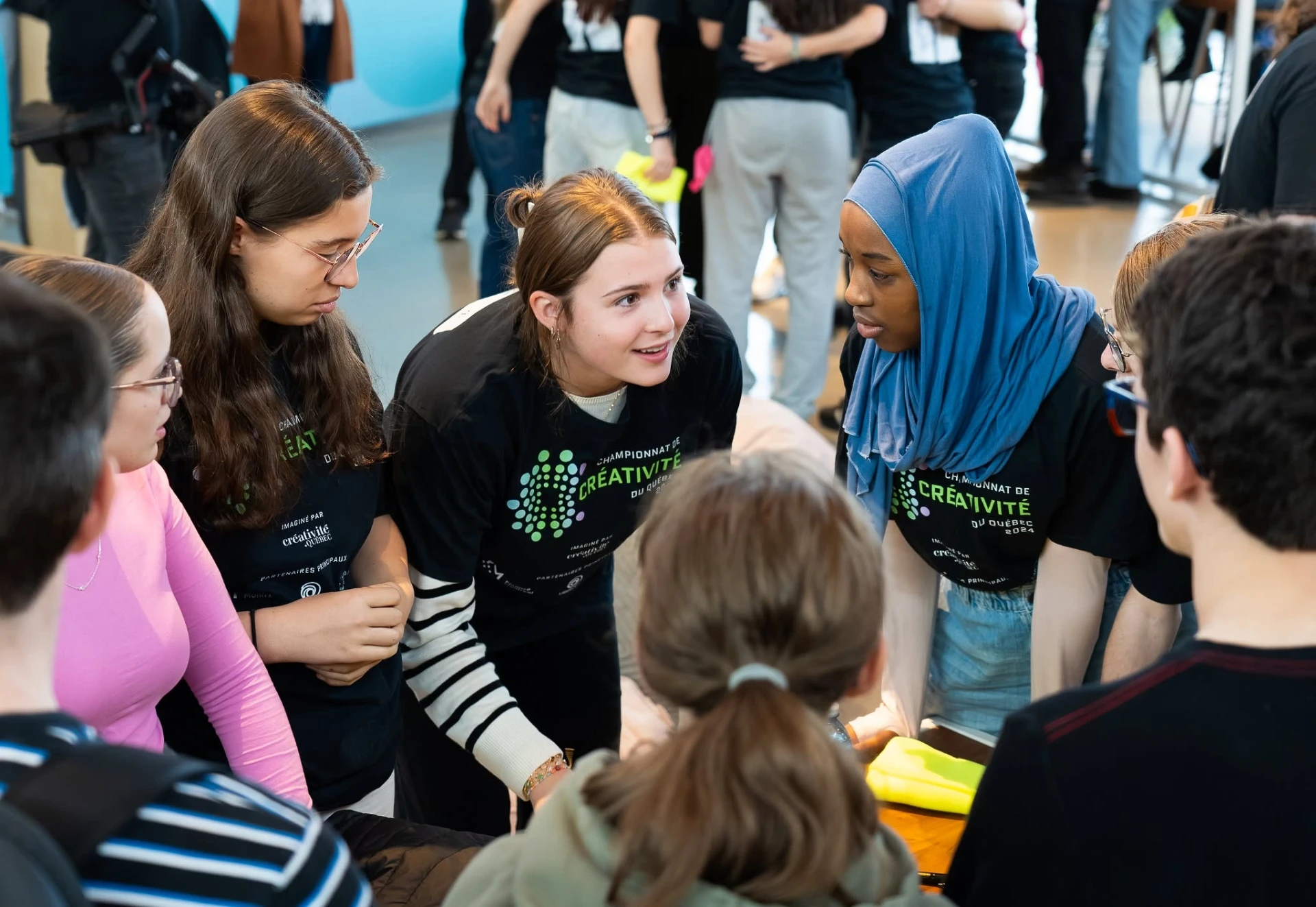 Cercle de jeunes en discussion lors d'un championnat de créativité — écoute, collaboration, intelligence collective.
